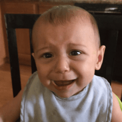 A Baby Wearing A Bib Is Crying While Sitting In A Chair GIF