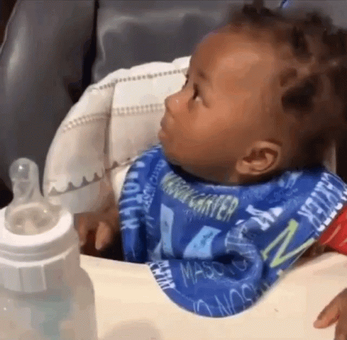 A Baby Wearing A Bib That Says Mason Is Sitting In A High Chair GIF