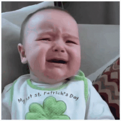 A Baby Wearing A Bib That Says My 1St St. Patrick 'S Day Cries GIF