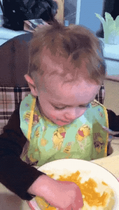 A Baby Wearing A Bib With Winnie Pooh On It GIF