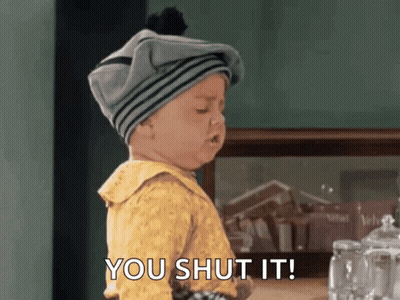 A Baby Wearing A Gray Hat And A Yellow Shirt Says You Shut It GIF