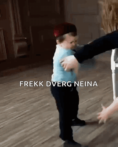A Baby Wearing A Hat Is Being Held By A Person . GIF