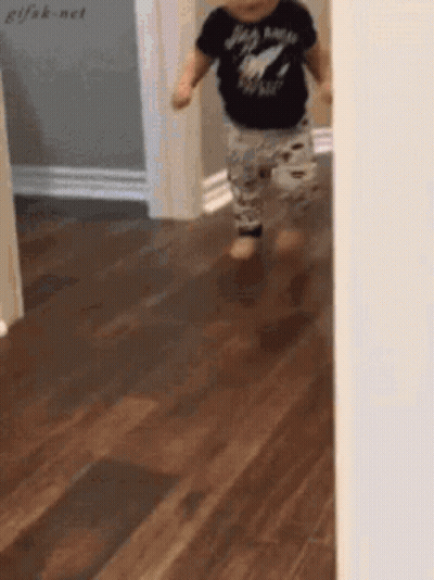 A Baby Wearing A Shirt That Says Rock N Roll Is Walking On A Wood Floor GIF