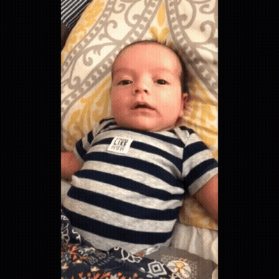 A Baby Wearing A Striped Shirt With A Label That Says Like Cow GIF