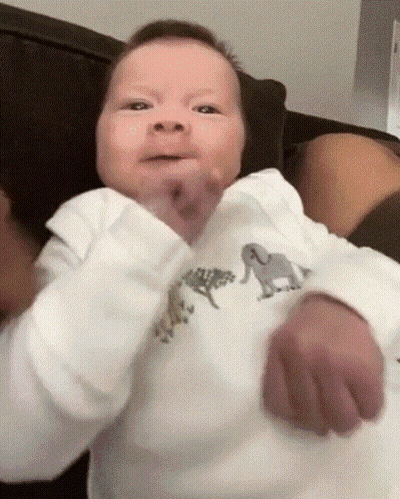 A Baby Wearing A White Shirt With Animals On It GIF