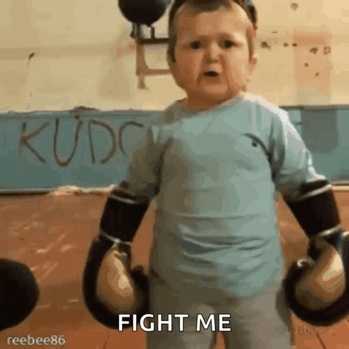 A Baby Wearing Boxing Gloves Says Fight Me In A Gym GIF