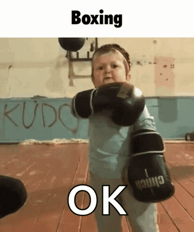 A Baby Wearing Boxing Gloves With The Word Ok Underneath GIF