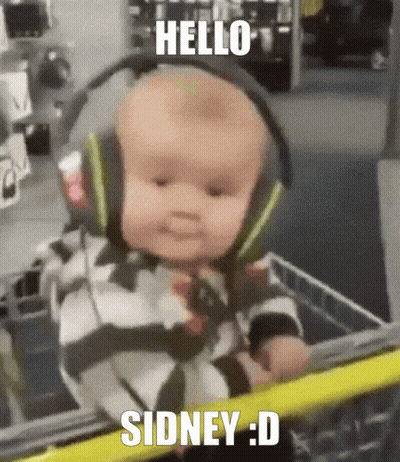 A Baby Wearing Headphones Is In A Shopping Cart And Says Hello Sidney : D GIF