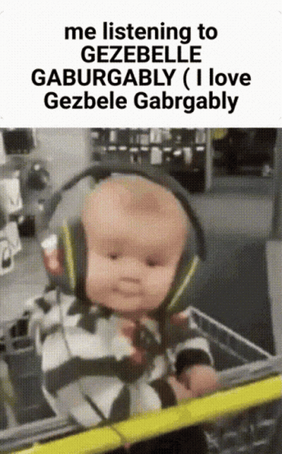 A Baby Wearing Headphones Is Sitting In A Shopping Cart .. GIF