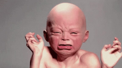 A Baby With A Bald Head Is Crying With His Eyes Closed . GIF