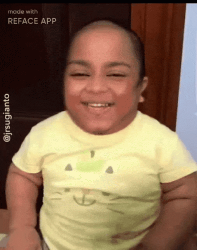 A Baby With A Cat On His Shirt Is Smiling GIF