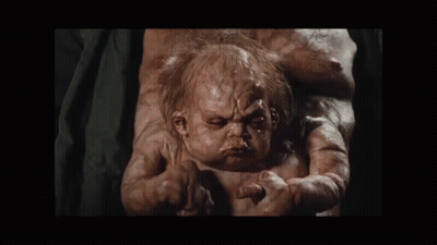 A Baby With A Very Ugly Face Is Being Held By A Woman GIF