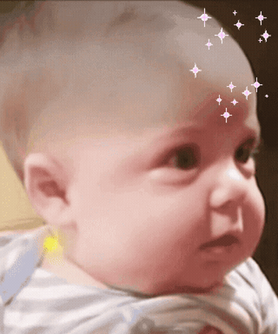 A Baby With Stars On His Forehead Looks At The Camera GIF