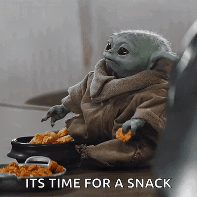 A Baby Yoda Is Sitting At A Table Eating Chicken Nuggets And A Bowl Of Chicken Nuggets . GIF