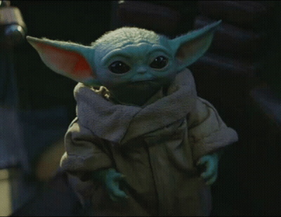 A Baby Yoda Is Wearing A Brown Coat GIF
