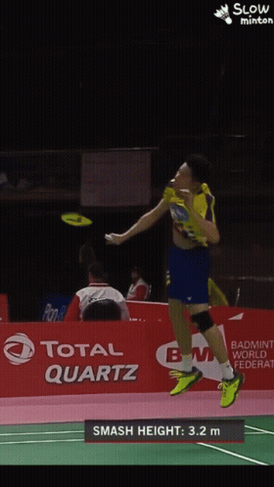 A Badminton Player Is Jumping In The Air In Front Of A Total Quartz Banner GIF