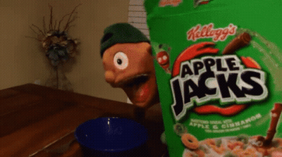 A Bag Of Apple Jacks Cereal Sits On A Table Next To A Blue Bowl GIF