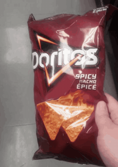 A Bag Of Doritos Spicy Nacho Epice Is Being Held In Someone 'S Hand GIF