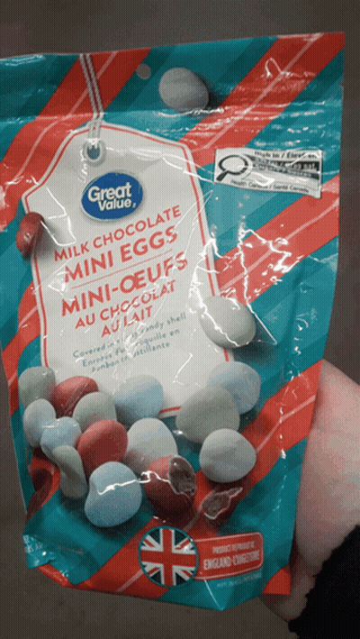 A Bag Of Milk Chocolate Mini Eggs Is Being Held In Someone 'S Hand GIF