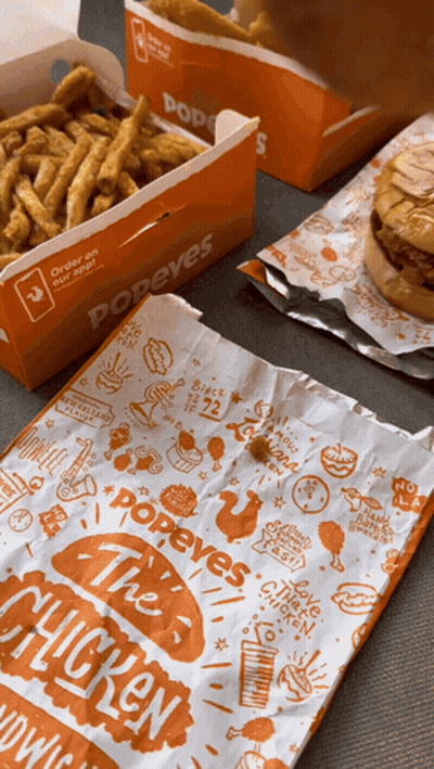 A Bag Of Popeye 'S Chicken Sits Next To A Box Of Fries GIF