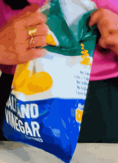 A Bag Of Salt And Vinegar Is Being Opened By A Woman GIF