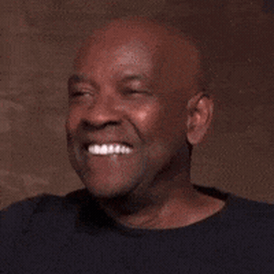 A Bald Man In A Black Shirt Is Laughing And Smiling . GIF