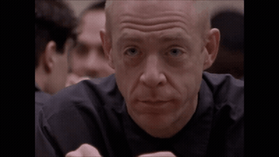A Bald Man In A Black Shirt Is Making A Face GIF