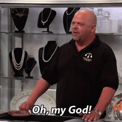 A Bald Man In A Black Shirt Is Standing In Front Of A Display Case And Says Oh My God GIF