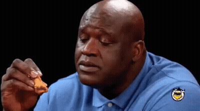 A Bald Man In A Blue Shirt Is Eating A Piece Of Fried Chicken GIF