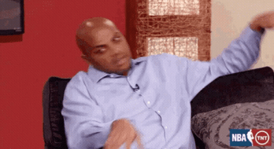 A Bald Man In A Blue Shirt Is Sitting On A Couch With His Arms Outstretched .. GIF