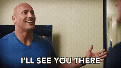 A Bald Man In A Blue Shirt Is Standing In Front Of A Mirror And Smiling . GIF