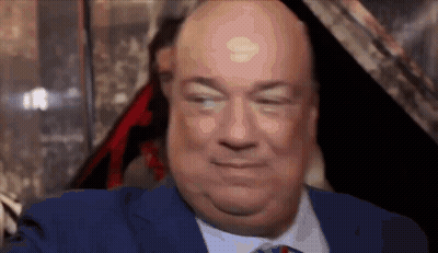 A Bald Man In A Blue Suit And Tie Is Smiling . GIF