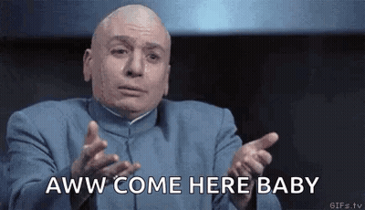 A Bald Man In A Blue Suit Is Making A Funny Face And Pointing At The Camera . GIF