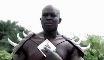 A Bald Man In A Costume With Horns Is Holding A Card . GIF