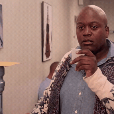 A Bald Man In A Leopard Print Jacket Holds A Piece Of Paper GIF