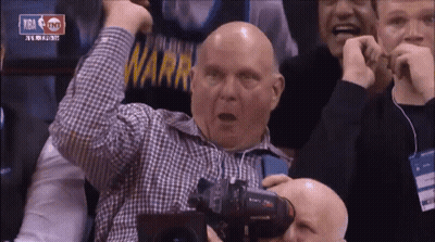 A Bald Man In A Plaid Shirt Holds His Fist In The Air While Watching A Basketball Game Sponsored By Tnt GIF