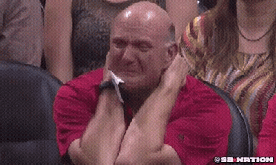 A Bald Man In A Red Shirt Is Crying In A Stadium . GIF