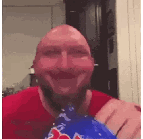 A Bald Man In A Red Shirt Is Holding A Bag Of Red Bull Candy Sticker
