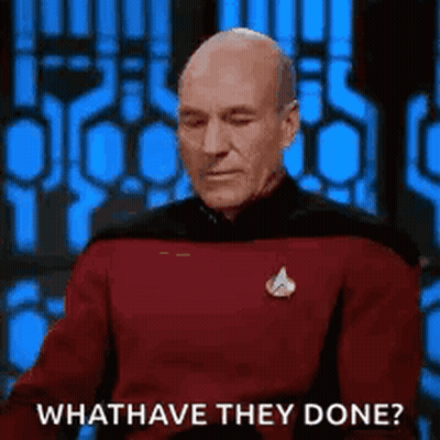 A Bald Man In A Red Shirt Is Sitting In Front Of A Blue Wall And Asking What Have They Done . GIF