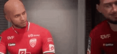 A Bald Man In A Red Soccer Jersey Is Standing Next To Another Bald Man In A Red Jersey . GIF