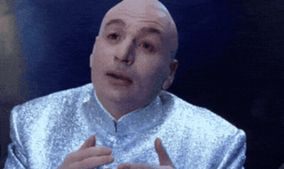 A Bald Man In A Silver Suit Is Talking GIF