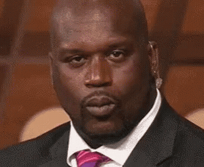 A Bald Man In A Suit And Tie Is Blowing A Kiss . GIF