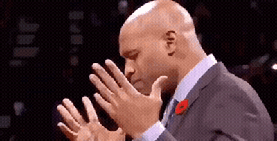 A Bald Man In A Suit And Tie Is Clapping His Hands Together . GIF