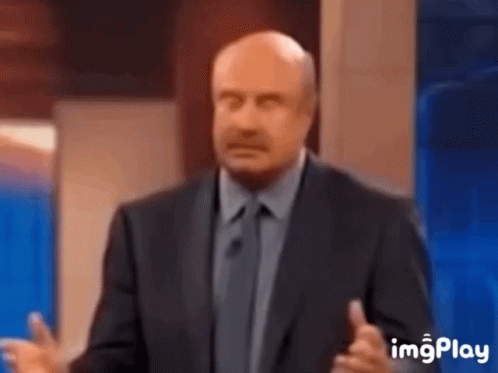 A Bald Man In A Suit And Tie Is Giving A Speech On A Television Show . GIF