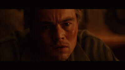 A Bald Man In A Suit And Tie Is Looking At Something GIF