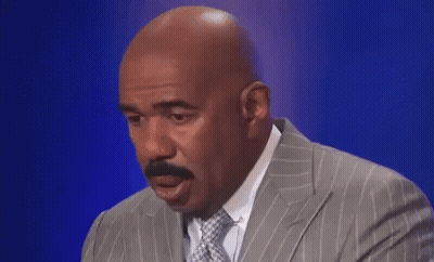 A Bald Man In A Suit And Tie Is Making A Funny Face . GIF
