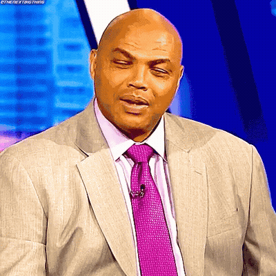 A Bald Man In A Suit And Tie Is Making A Funny Face .. GIF