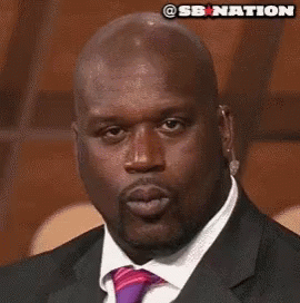 A Bald Man In A Suit And Tie With A Sb Nation Logo Above His Head GIF