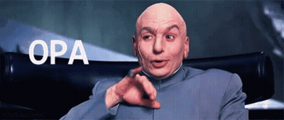 A Bald Man In A Suit Is Pointing At The Camera With The Word Opa Behind Him GIF