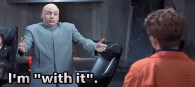 A Bald Man In A Suit Is Standing In Front Of A Man In An Orange Jacket . GIF